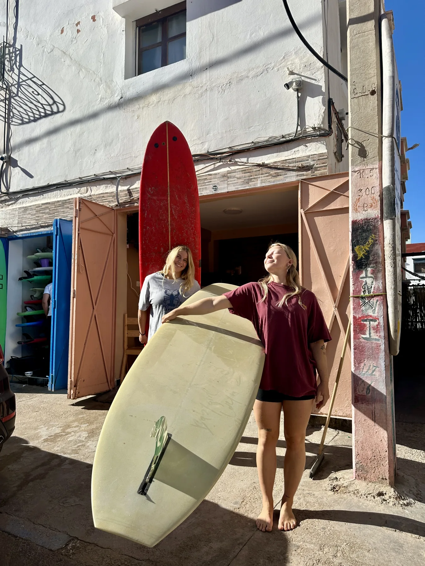 Friends with surfboards outside the Momma Surfs shop