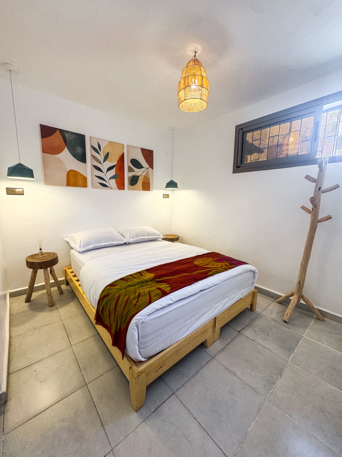 Double bedroom with white bedding, a patterned throw and wooden bedside tables