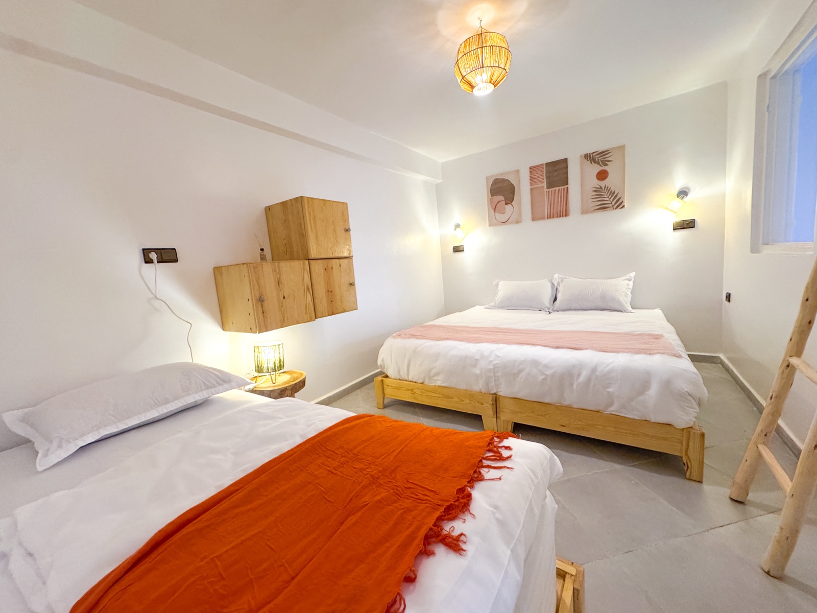 Triple bedroom with a double bed and a single bed with an orange throw